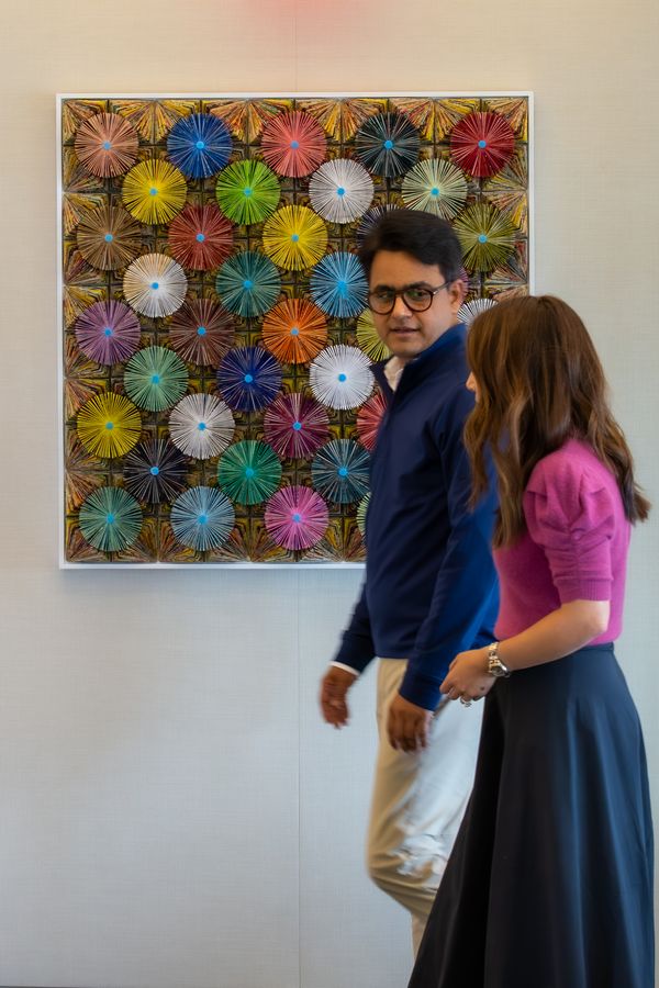 Two Astira colleagues walking past the artwork in the office